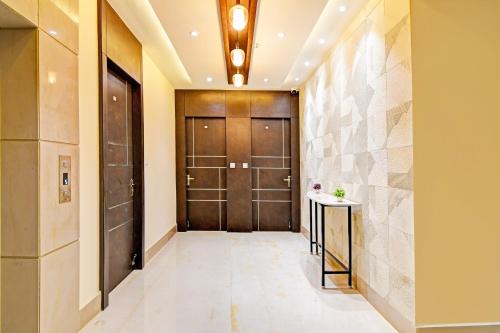 a hallway with a wooden door and a tile wall at Super Hotel O SAMOTEL in kolkata