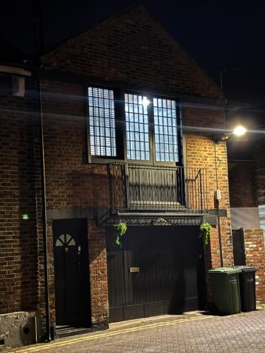 a brick building with a balcony and a door at The workshop in King's Lynn