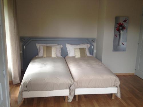 a bedroom with two beds with white sheets and a blue headboard at Beluga in La Godivelle