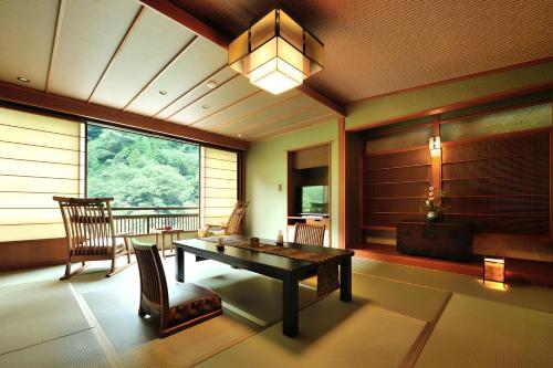 a dining room with a table and chairs and a window at 山の茶屋 in Hakone