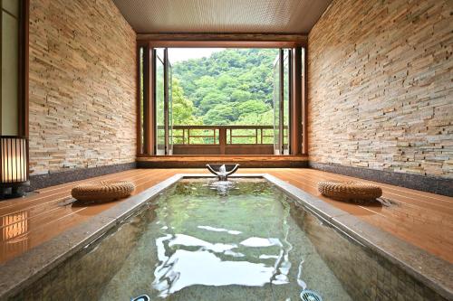 a swimming pool in a room with a large window at 山の茶屋 in Hakone