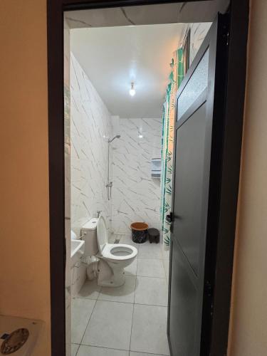 a bathroom with a toilet and a sink at Cozy Bright Family Apartment Near City Center in Tagadirt