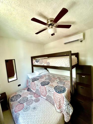 a bedroom with a bed with a ceiling fan at Sumergete Nueva Residencia en Playa del Carmen in Playa del Carmen