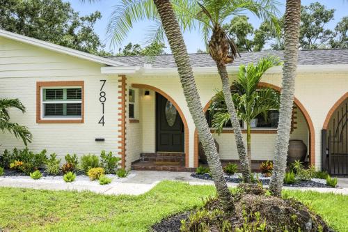 a house with palm trees in front of it at Luxury Oasis Retreat Pickleball Pool Spa Billiard Gaming in Tampa