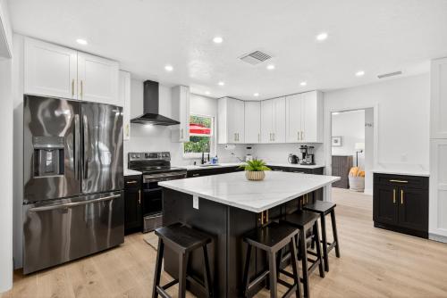a kitchen with black and white appliances and a table at Luxury Oasis Retreat Pickleball Pool Spa Billiard Gaming in Tampa