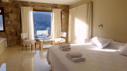a bedroom with a bed and a large window at canto del viento in Tilcara