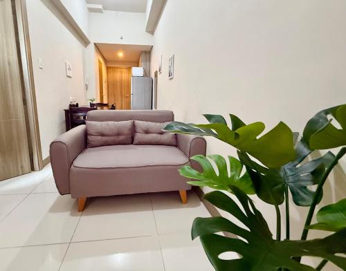 a living room with a couch and a plant at Coast Residences 40th Floor Penthouse Pasay Manila in Sampong