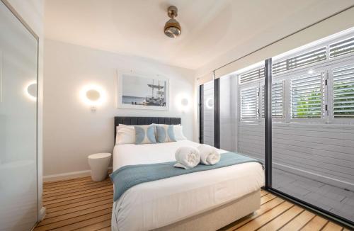 a bedroom with a bed with two towels on it at Marina Living with views and more in Airlie Beach