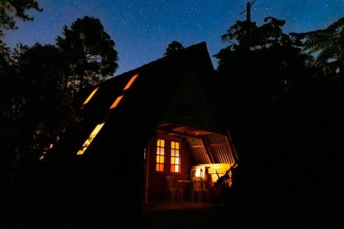a small cabin with a window at night at Chalé Aconchegante, Tapiraí-SP in Tapiraí