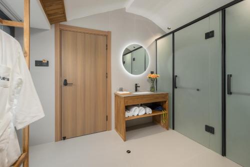 a bathroom with a sink and a mirror at Flower Hotel Jiuhuashan Blossoms Not Yet Full in Chizhou