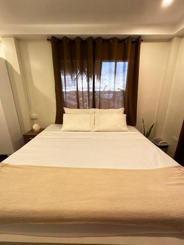 a bedroom with a large bed with a window at Captain CLIFFs House in Pilar