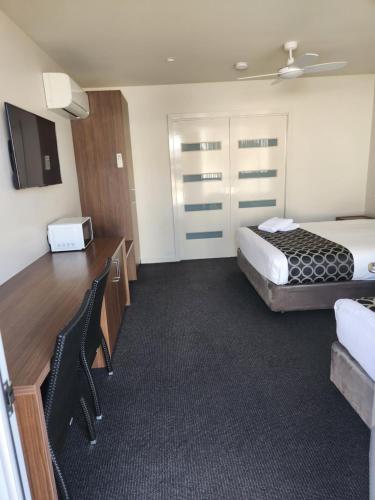 a hotel room with a bed and a desk at Jane Eliza Motor Inn in Swan Hill