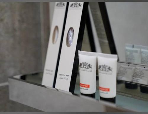 a shelf with three bottles of moisturizers on it at مساكن الراحه للشقق المخدومة in Abha