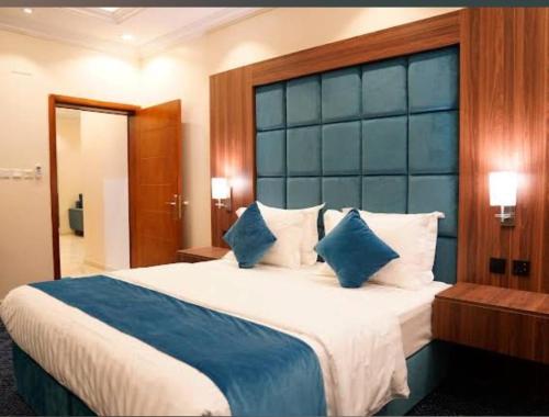 a bedroom with a large bed with a blue headboard at مساكن الراحه للشقق المخدومة in Abha