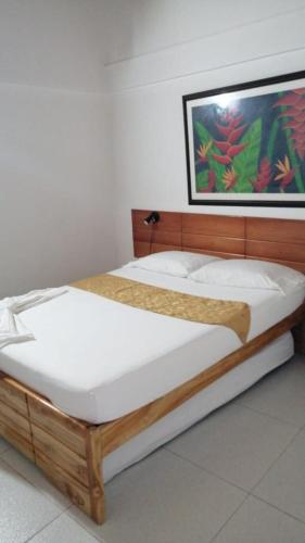 two beds in a bedroom with a picture on the wall at Hotel Santiago Plaza Acandí in Acanti