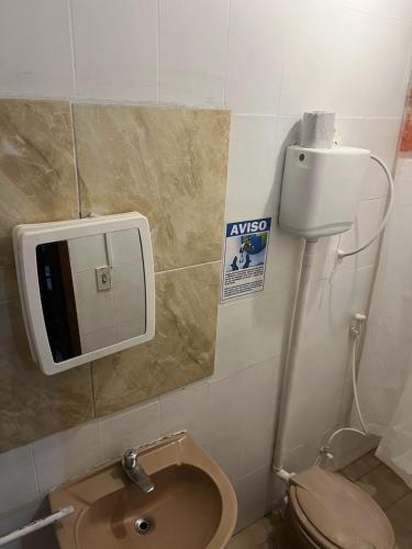 a bathroom with a toilet and a sign on the wall at Pousada Sol de Iracema - Praia Centro in Fortaleza