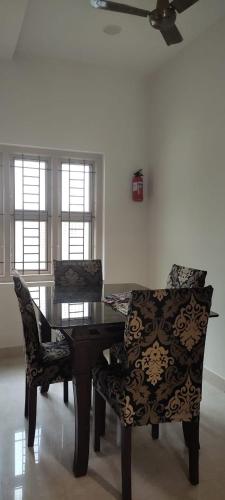 a dining room table with two chairs and a ceiling fan at Blissfull stay in Udupi! in Udupi