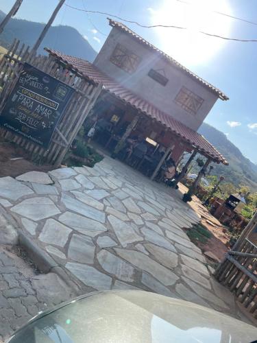 un edificio con una pasarela de piedra frente a un edificio en Hospedagem Toca das lobas, en São Thomé das Letras