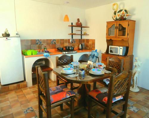 eine Küche mit einem Tisch mit Stühlen und einer Mikrowelle in der Unterkunft El Bello Jardín de Chela in Guanajuato