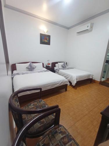 a room with two beds and a chair in it at Du Hung 2 Hotel in Ha Tien