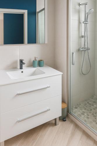 Un baño blanco con lavabo y ducha. en Villa bel azur, en La Trinité