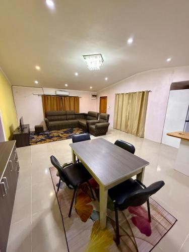 a living room with a wooden table and chairs at RN Homestay Nadi Fiji in Nadi International Airport