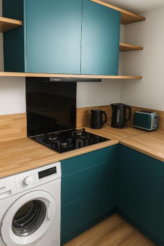 una cocina con estufa y lavadora en Villa bel azur, en La Trinité