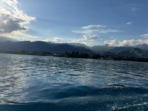 a large body of water with mountains in the background at 1 комнатная квартира на Иссык Куле пансионата Радуга in Chon-Sary-Oy