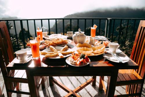een tafel met borden eten op een balkon bij Best View Guest Inn Ella in Ella