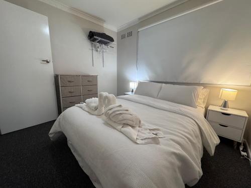 a bedroom with a white bed with a towel on it at 1 Turf St Workers Accommodation in Grafton