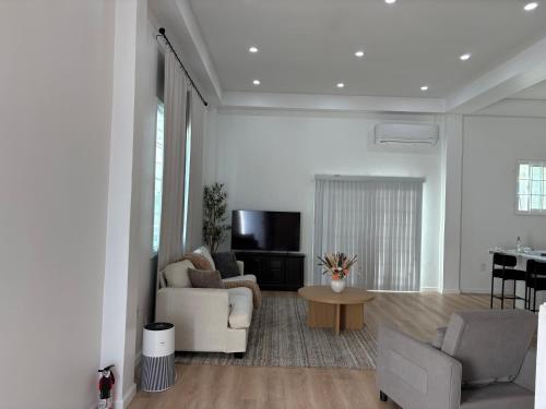 a living room with a couch and a tv at Luxury Apartments in Georgetown