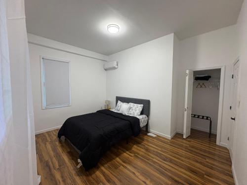a bedroom with a black bed in a white room at Luxury Apartments in Georgetown