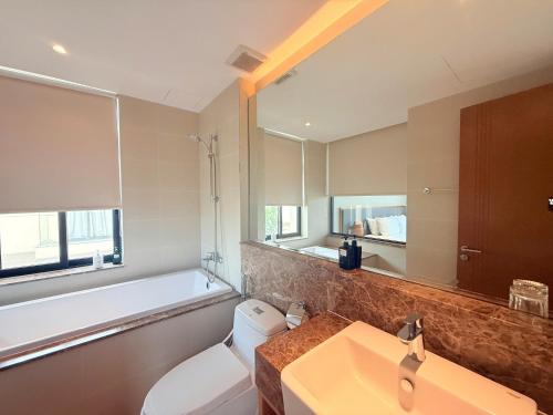 Un baño con lavabo, inodoro y bañera. en Luxury 3BR BeachFront, en Cam Lâm