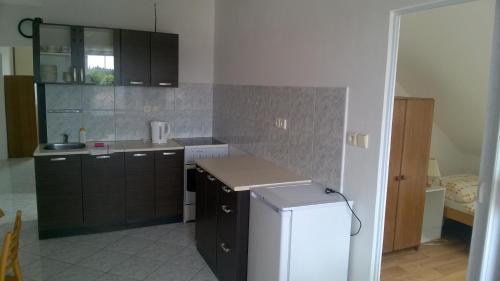 eine Küche mit braunen Schränken und einem weißen Kühlschrank in der Unterkunft Hotýlek.eu in Chlum u Třeboně