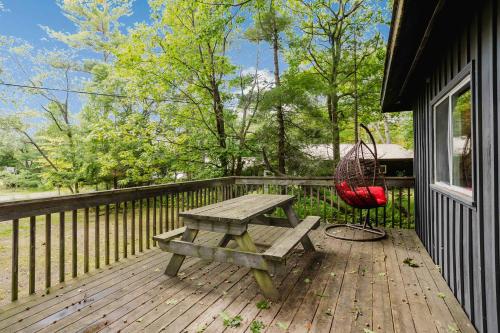 une terrasse en bois avec une table de pique-nique et une balançoire dans l'établissement 2-Bedroom Cottage #6 - Sand Bay, à Dillon