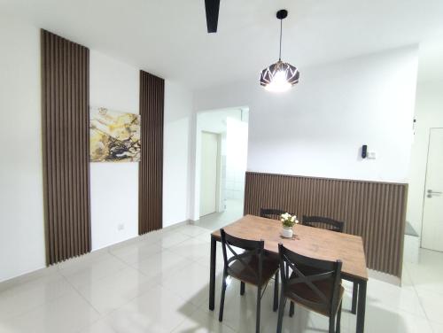 a dining room with a wooden table and chairs at Mawaddah Homestay Sireh Residence in Kota Bharu