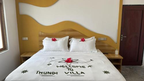 a bed with two pillows with a welcome to timiny villa on it at Thundi Villa in Maalhos