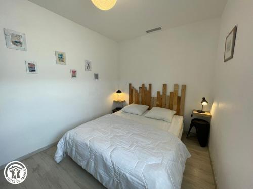 ein Schlafzimmer mit einem weißen Bett und zwei Lampen in der Unterkunft Maison climatisée proche plage à Saint-Hilaire-de-Riez - FR-1-426-591 in Saint-Hilaire-de-Riez