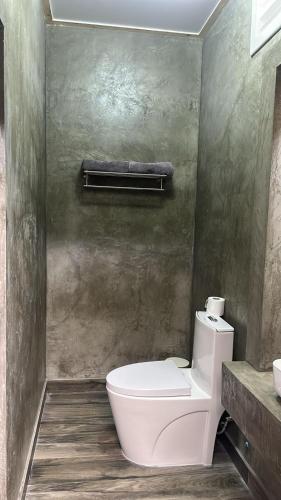 a bathroom with a white toilet and a sink at Thundi Villa in Maalhos
