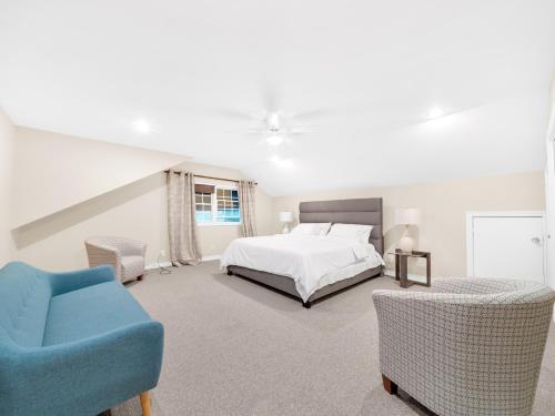 une chambre avec un lit et une chaise bleue dans l'établissement The Splash & Stay Villa, à Belle River