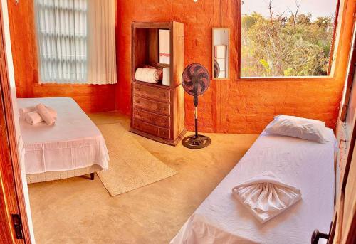 Un dormitorio con dos camas y un espejo. en Vila Kuir Hospedagens, en Alto Paraíso de Goiás