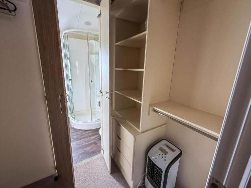 an empty closet with a sink and a mirror at Stunning Lodge With Full Sea Views At Coopers Beach Holiday Park Ref 49019S in East Mersea