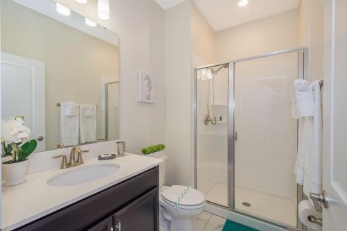 a bathroom with a toilet and a sink and a shower at Stunning Townhouses 5 Minutes away Disney! in Kissimmee
