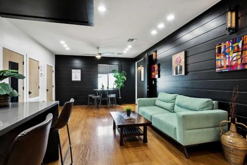 a living room with a green couch and a table at 5 bedroom Villa w private rooftop in New Orleans