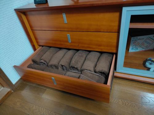 a wooden dresser with a drawer with towels in it at 4BR Entire House near Nikko & Highway EV Parking in Nikko