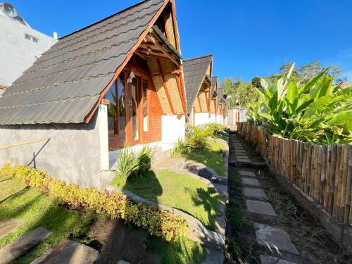 a row of houses with a wooden fence at Bali Sunrise Camp & Glamping in Kintamani