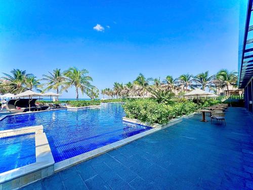 una gran piscina con sillas y sombrillas en un complejo en Luxury 3BR BeachFront, en Cam Lâm