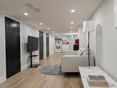a living room with a couch and a tv at The Urban Hideaway - Stylish Stay - Prime Spot in Hamilton