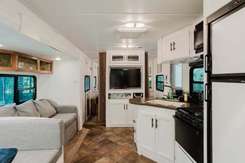 ein Wohnzimmer mit einem Sofa und eine Küche in einem Wohnwagen in der Unterkunft 2-bedroom Camper Trailer Cottage #3 in Dillon