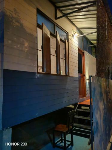 a porch of a house with a table and two windows at nature in Ban Rong Koet